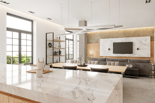 Modern open plan apartment kitchen and dining room interior. Marble countertop, wooden dining table, chairs, pillars, shelf, windows, wooden wall, pendant lamp and TV set in the background. Copy space template. Render.
